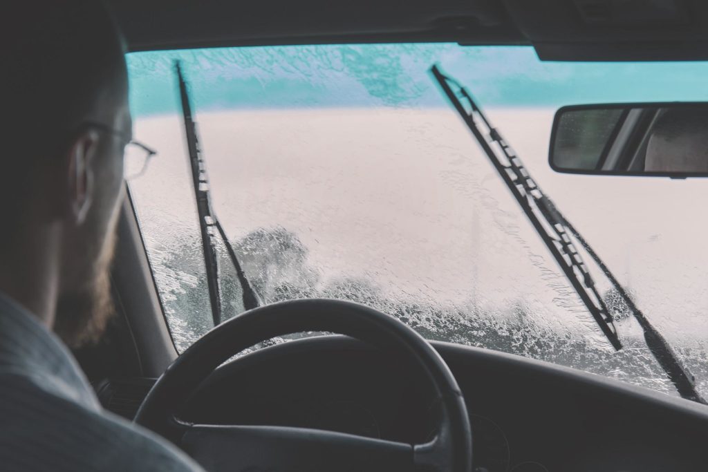 man driving using windshield wiper